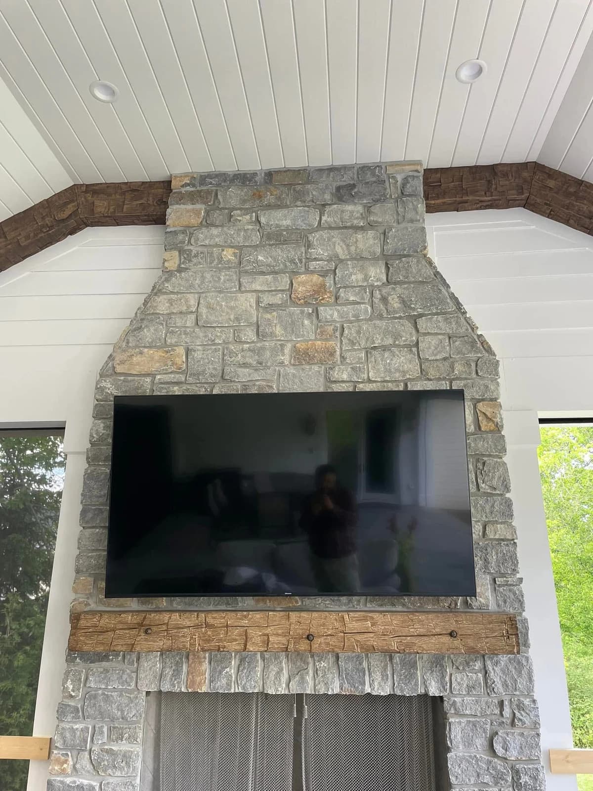 Before color matching, the ceramic fireplace mantel appears lighter than the existing darker wood beams.