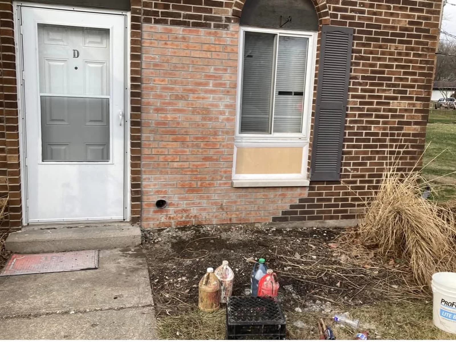 Before color correction, a pale orange rectangular brick repair stands out beside darker existing brick.